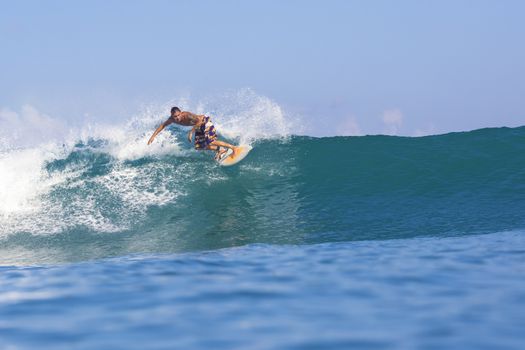 Surfer on Amazing Blue Wave, Bali island.