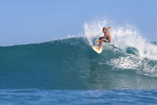 Surfer on Amazing Blue Wave, Bali island.