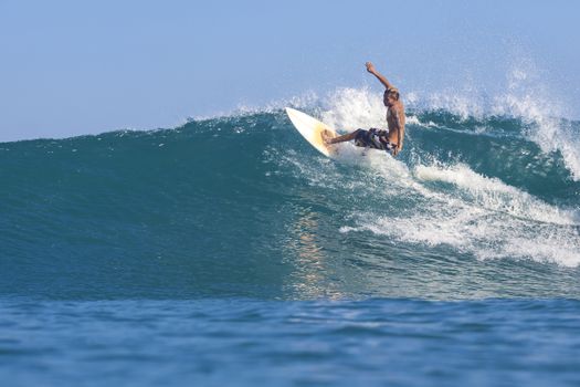 Surfer on Amazing Blue Wave, Bali island.