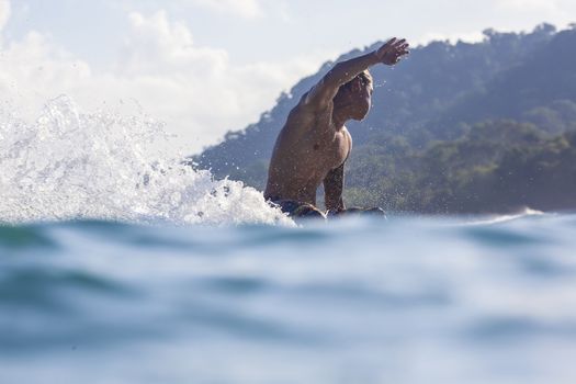 Surfer on Amazing Blue Wave, Bali island.