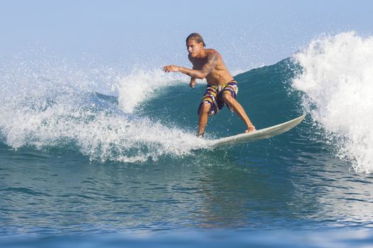 Surfer on Amazing Blue Wave, Bali island.