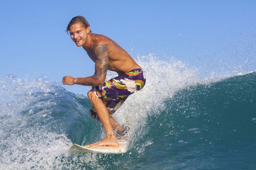 Surfer on Amazing Blue Wave, Bali island.