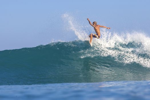 Surfer on Amazing Blue Wave, Bali island.