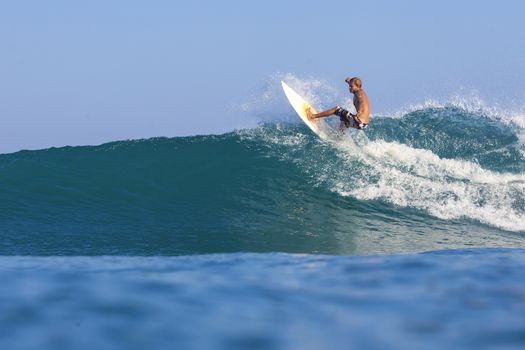 Surfer on Amazing Blue Wave, Bali island.