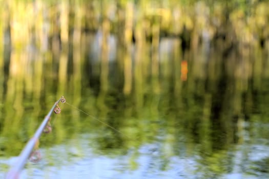 fishing rod in creeks with boats in the summer