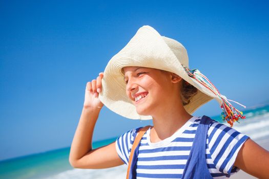 Summer vacation, lovely girl walking on the beach near water