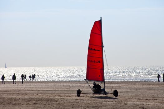 IJMUIDEN, THE NETHERLANDS -MARCH 20TH 2011: Beach sailing cart (Blokart) with red sail on the beach in IJmuiden on March 20th 2011 