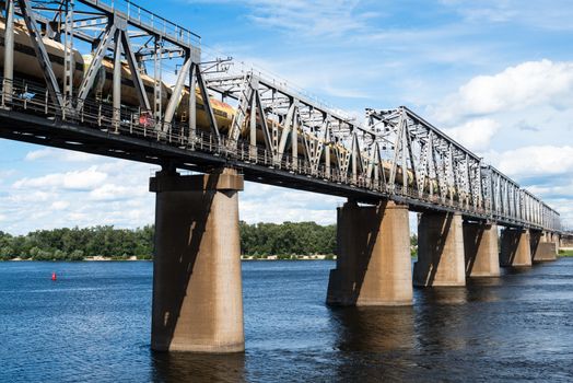 Petrivskiy railroad bridge in Kyiv across the Dnieper with freight train on it.