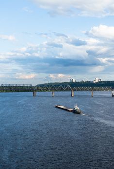 The barge floating in the blue Dnieper waters against the summer Kyiv landscape.