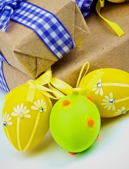 Yellow and Green Easter Eggs  with Gift Boxes and Ribbons closeup on white background