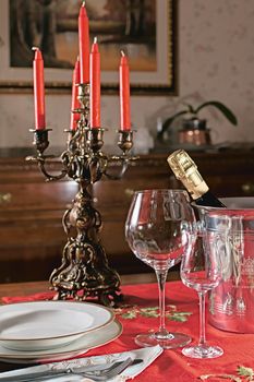 supper table with candlestick , glasses and plates