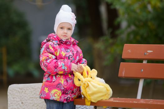 Girl three years walking on the Playground in cool autumn weather