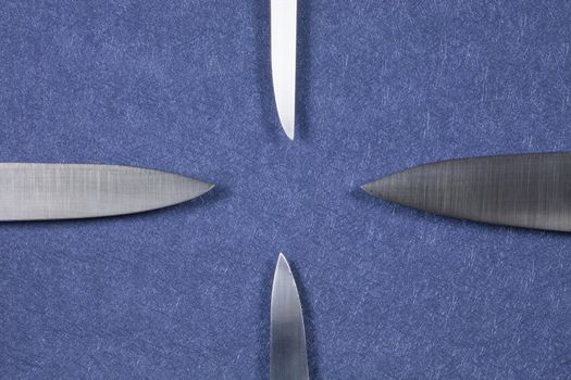 four big kitchen knife bright silver blades on blue background