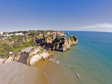 Aerial from rocks and ocean at Praia tres Irmaos in Algarve Portugal