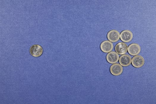 One Euro coins in two groups on blue background