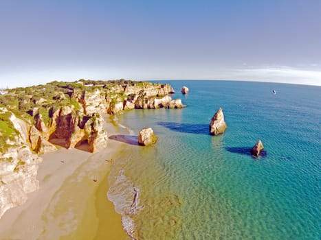 Aerial from rocks and ocean at Praia tres Irmaos in Algarve Portugal