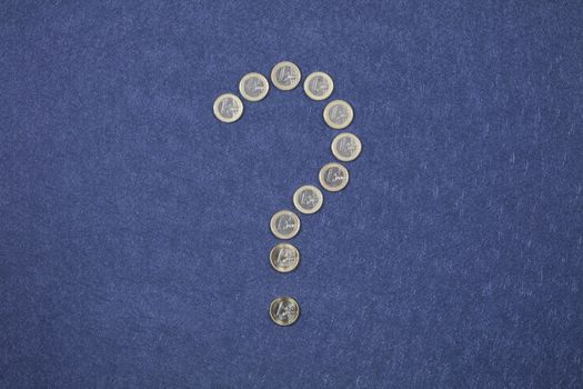 one Euro coin between five ten twenty fifty banknotes on blue background
 euro coins as a question mark on blue background