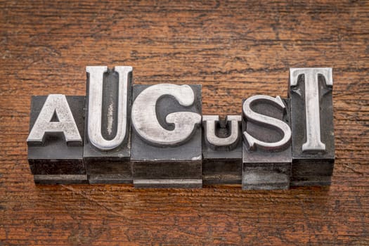 August  word in mixed vintage metal type printing blocks over grunge wood