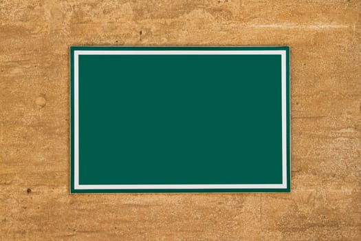Blank green board sign with space on wall for your designs.