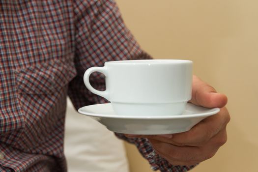 Man holding white cup of coffee with his hand.