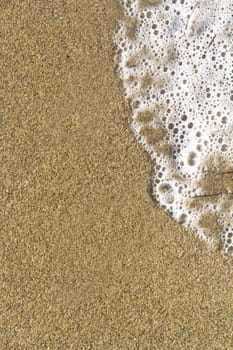 Sand and sea foam with space.