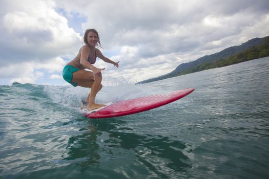 Surfer girl on Amazing Blue Wave, Bali island.