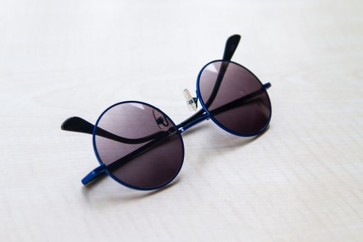Side view of sun glasses on wooden table.