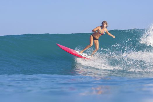 Surfer girl on Amazing Blue Wave, Bali island.