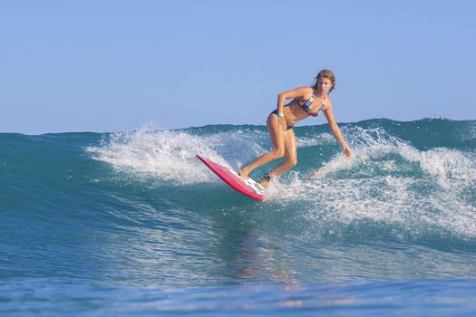 Surfer girl on Amazing Blue Wave, Bali island.