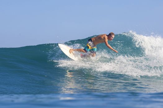 Surfer on Amazing Blue Wave, Bali island.