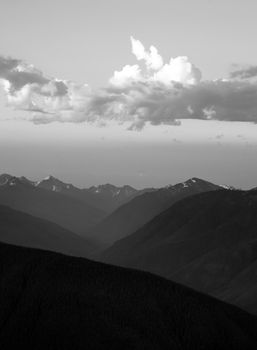 The Olumpic Mountains stand against a dramatic sky at sunrise