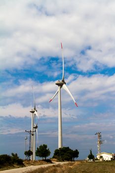 Group of windmills for renewable energy on cloudy background.