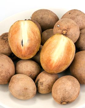 fresh Sapodilla - whole and half cut on white background