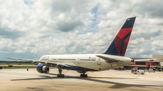 Atlanta - Aug 30: A ground technician at Atlanta International Airport directs a delta air plane out of its departure gate for takeoff on Aug 30, 2014 in Atlanta, Georgia.