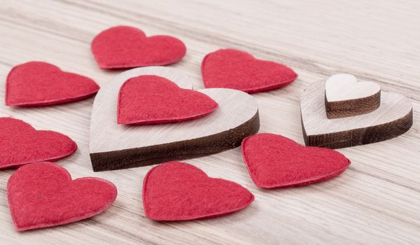 valentine's wooden and fabric hearts on a wooden background , valentine's day , day valentine postcard with space for text