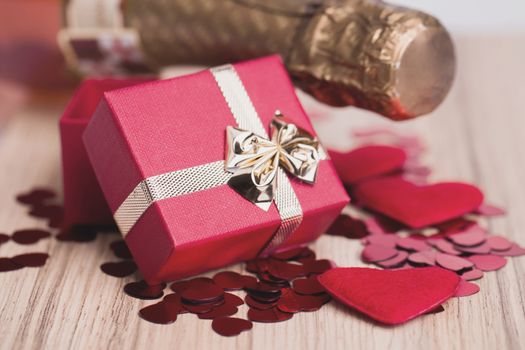 Valentines day: bottle of vine, red hearts and small present