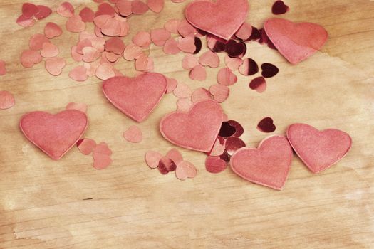 valentine's wooden and confetti hearts on a wooden background , valentine's day , retro color tone