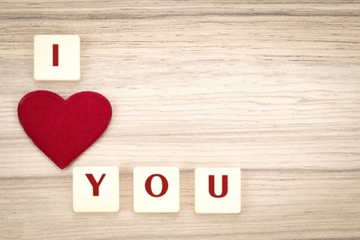 valentine's hearts on a wooden background , valentine's day , day valentine postcard with scrabble text I love you