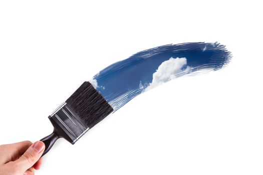 Male hand holding paint brush and painting blue and cloudy sky, isolated on white background.