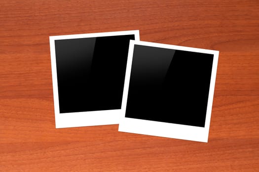 Blank, black picture frames with copy space on wooden table.