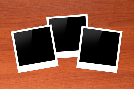 Blank, black picture frames with copy space on wooden table.