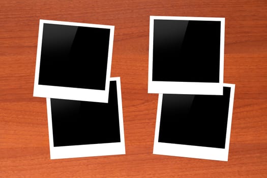 Blank, black picture frames with copy space on wooden table.