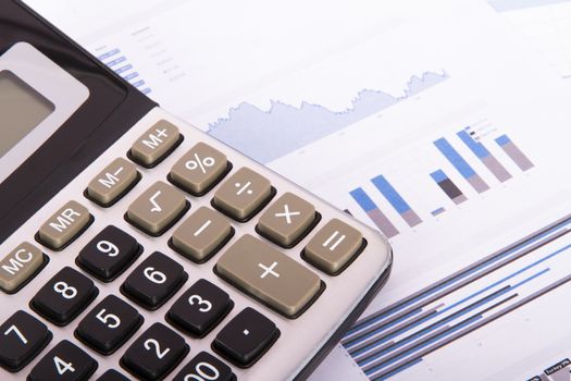 Calculator on financial data graphs.