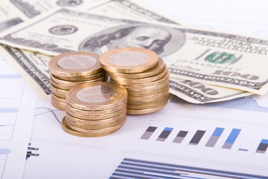 Dollar banknotes and coins on bar chart graphic results.