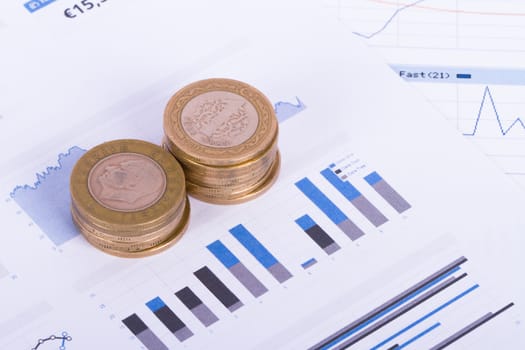 Coins on chart graphs and financial data analysis.