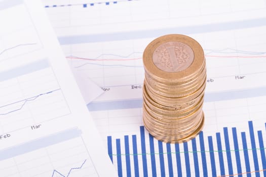 Coins on chart graphs and financial data analysis.