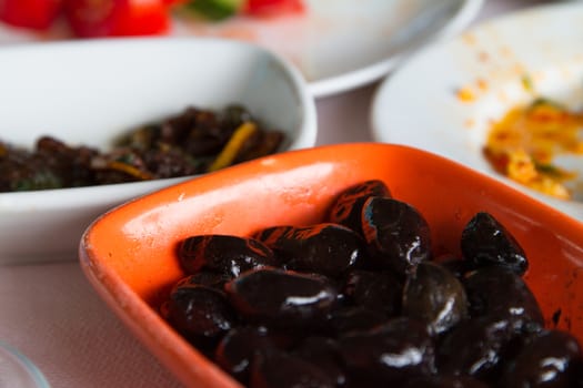Breakfast service, black olives on table.