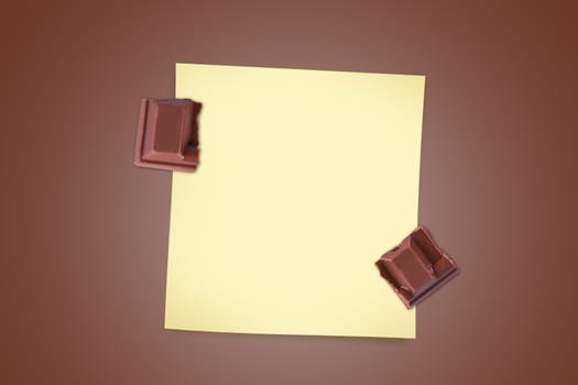 Top view of milk bar chocolate pieces with yellow sticky note paper for your message on brown background.