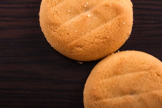 Close up and top view of biscuit cookies on wooden table.