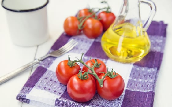  few fresh ripe tomatoes on a branch with olive oil